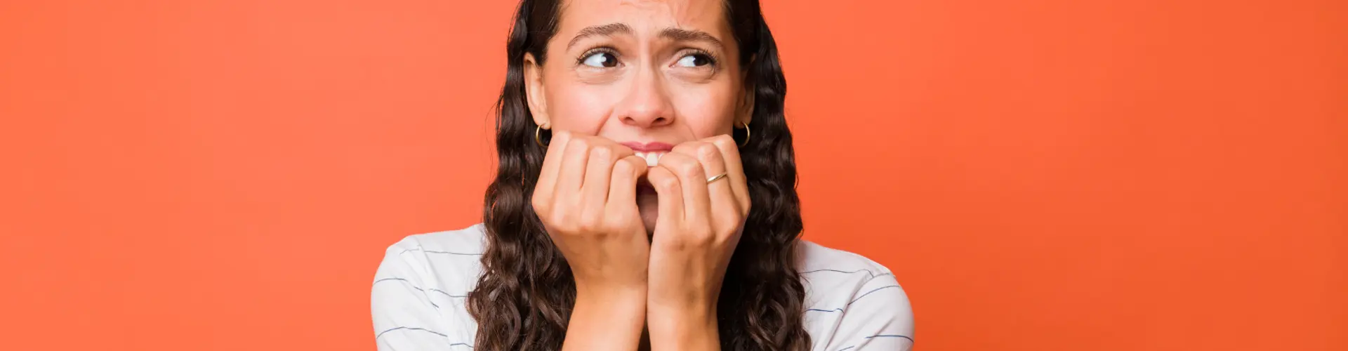 Frau hat Angst und hält sich die Hände vor den Bund