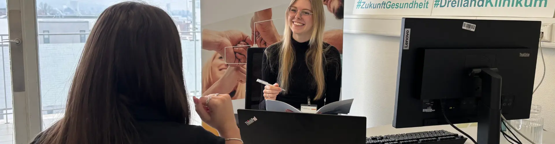 Eine Frau im Austausch mit einer Mitarbeiterin des Kreiskrankenhaus Lörrach