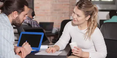 Eine Frau, die Geschäftsideen mit einem Kollegen teilt