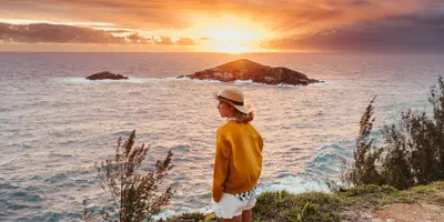 Frau genießt Sonnenuntergang über dem Meer