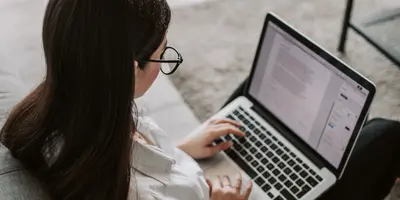 Frau, die zu Hause mit ihrem Laptop arbeitet