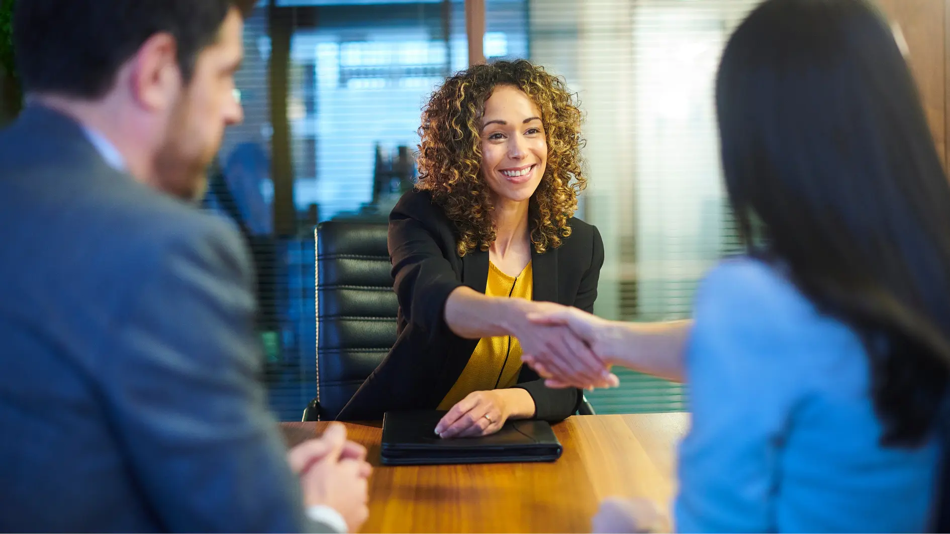 Eine Frau schüttelt die Hand einer anderen Frau während eines Gesprächs