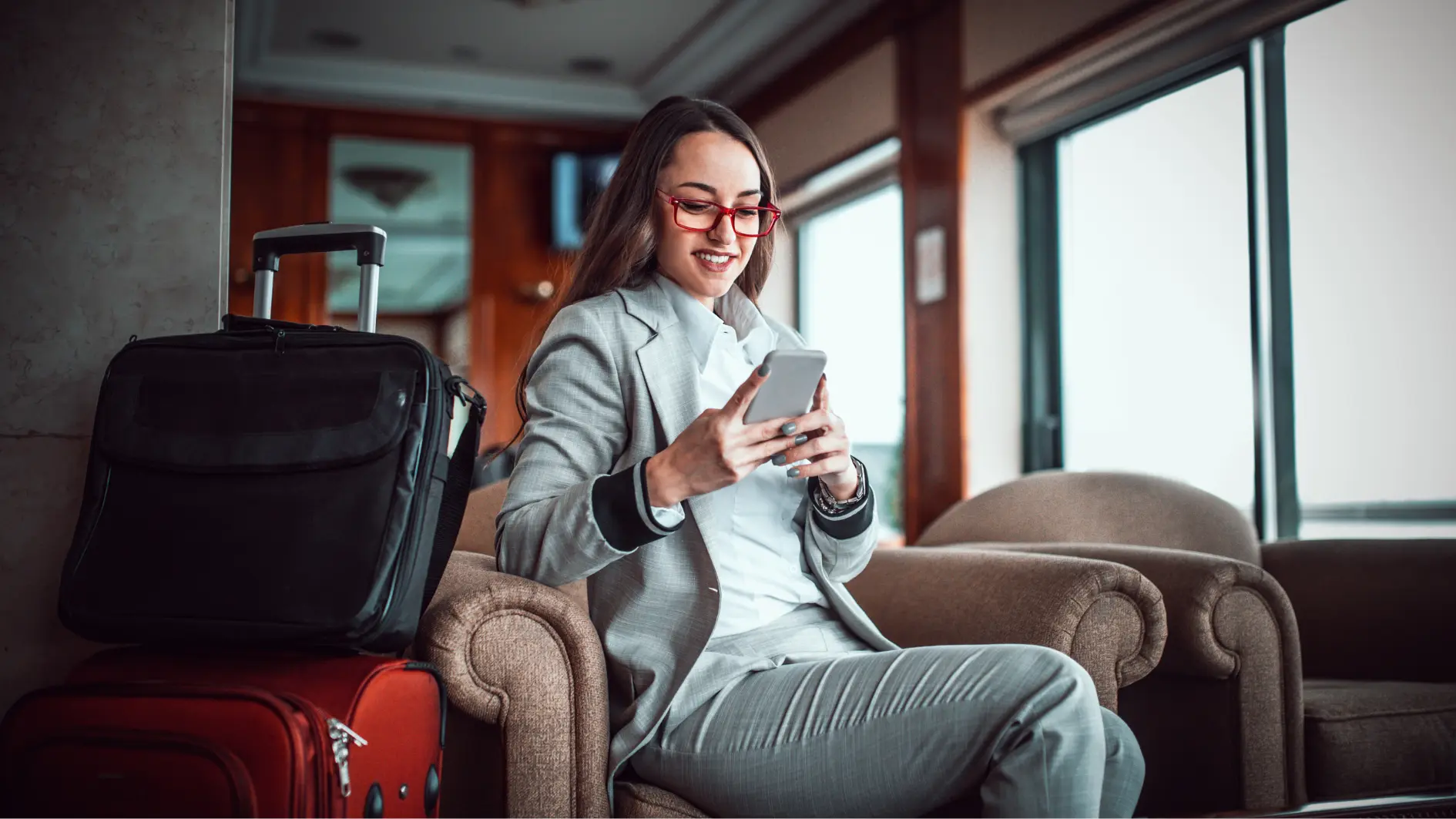 Karrierefrau mit ihrem Gepäck in einer Hoteleingangshalle