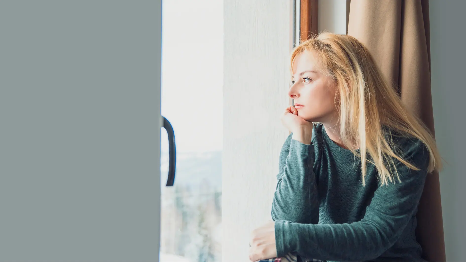 Frau schaut aus dem Fenster
