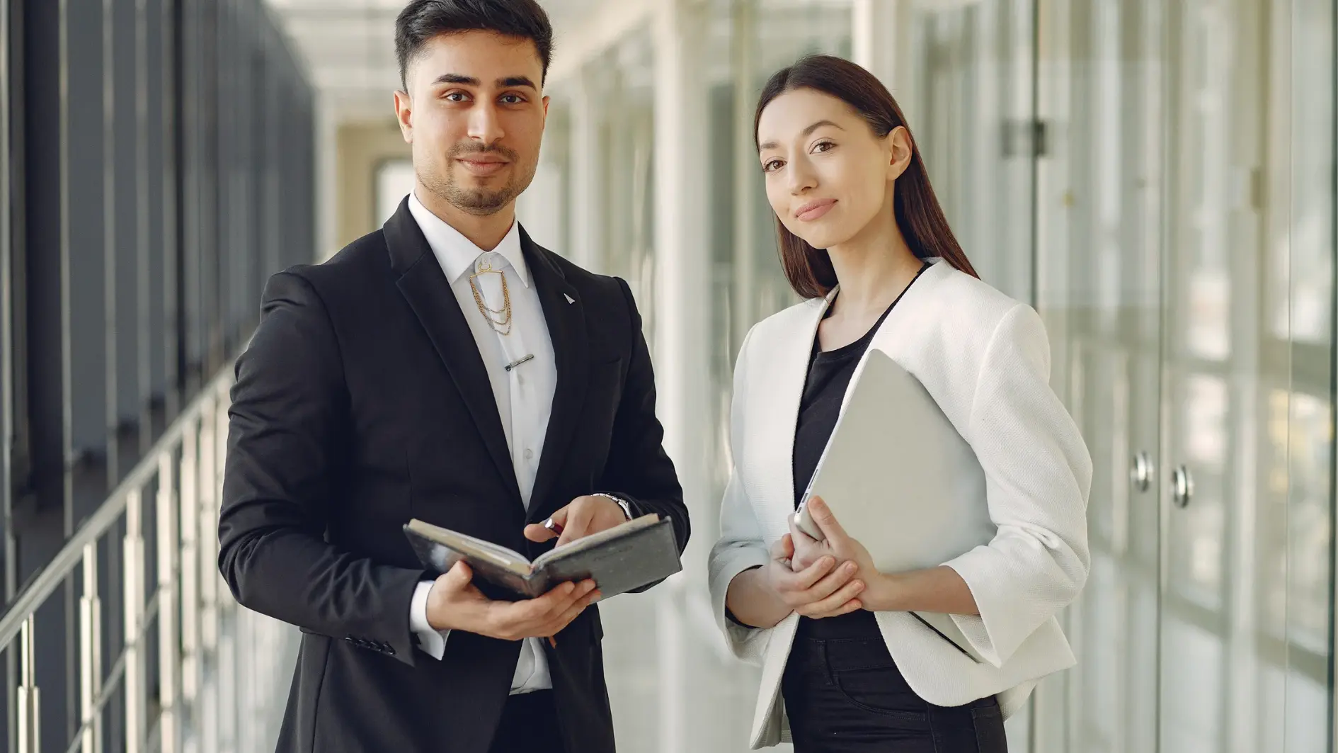 Zwei Mitarbeiter stehen in einem modernen Büro