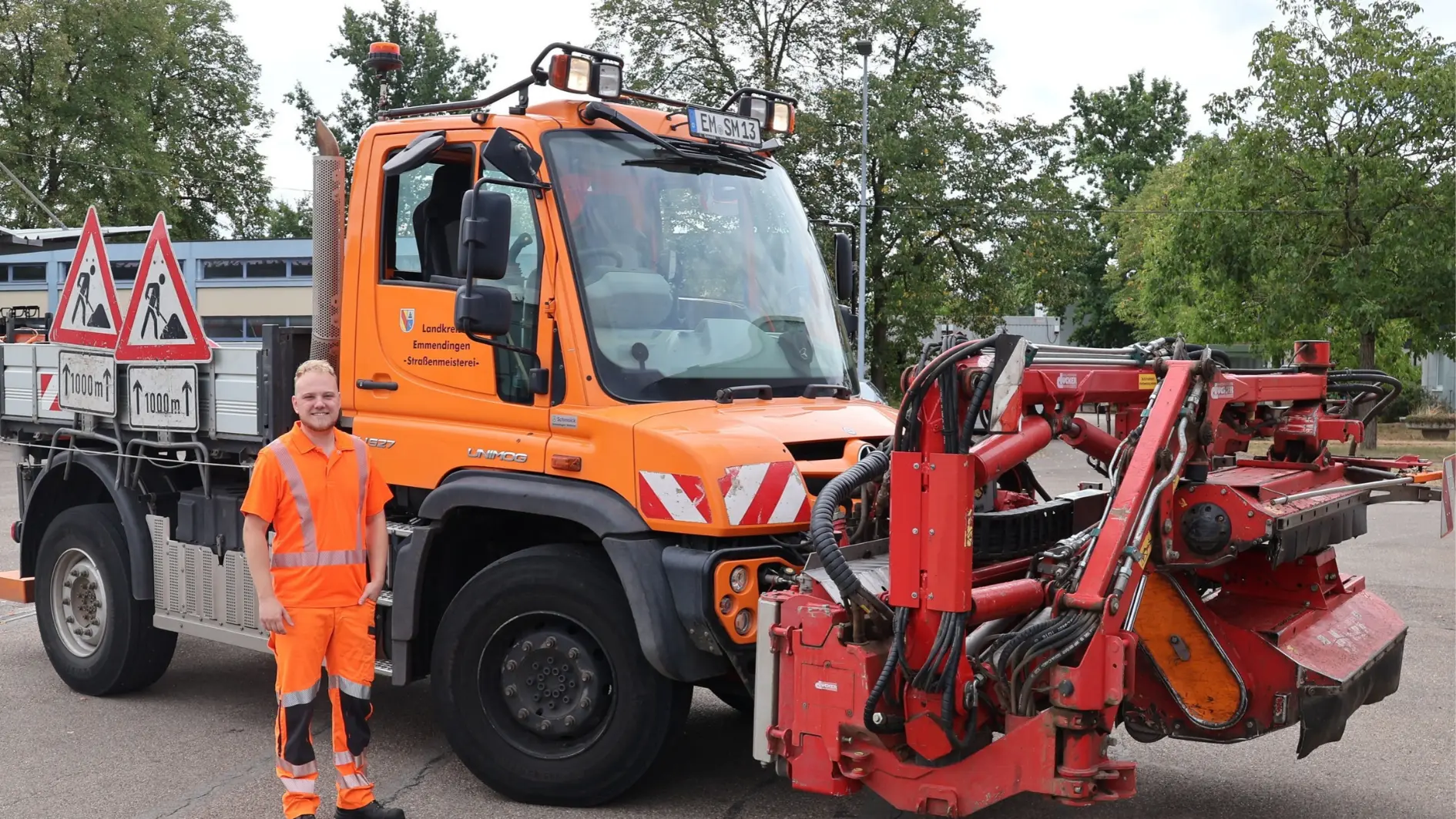 Ein Mitarbeiter der Straßenmeisterei steht vor einem Unimog